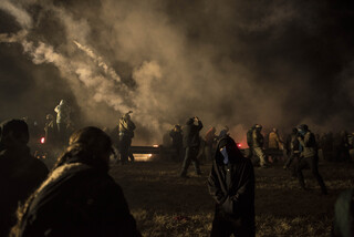 Law enforcement releases tear gas to disperse the crowd of nonviolent water protectors gathered at the barricade on Nov. 20. The barricade, erected three weeks prior when protectors marched toward the pipeline, was being cleared from wreckage when protectors arrived from the nearby camp.